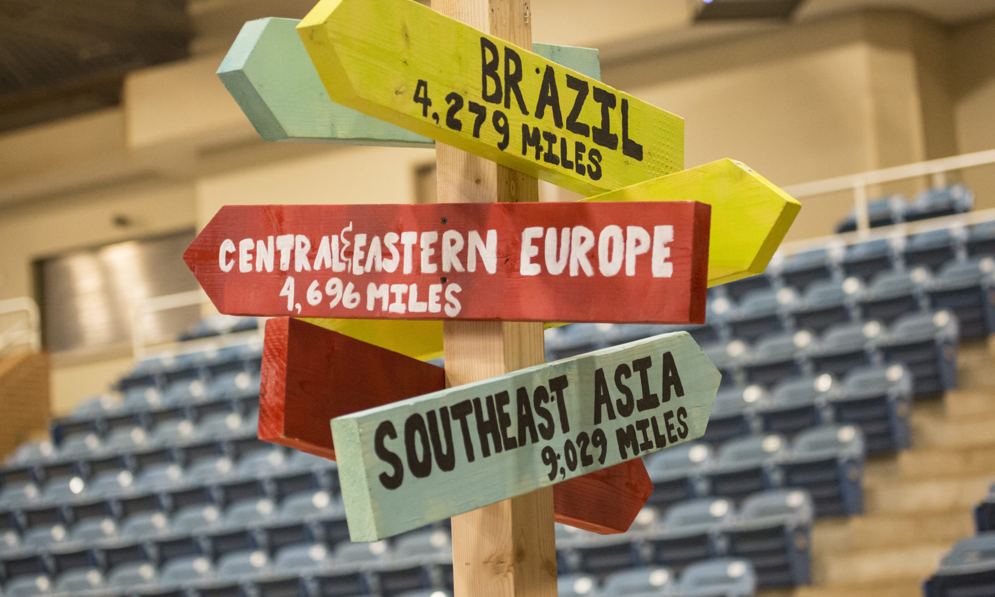 Sign pointing to different countries and regions around the world.