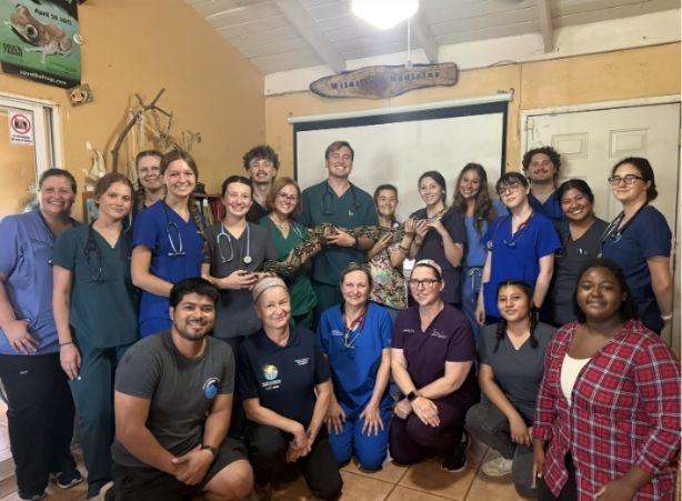 A group of students holding a snake.