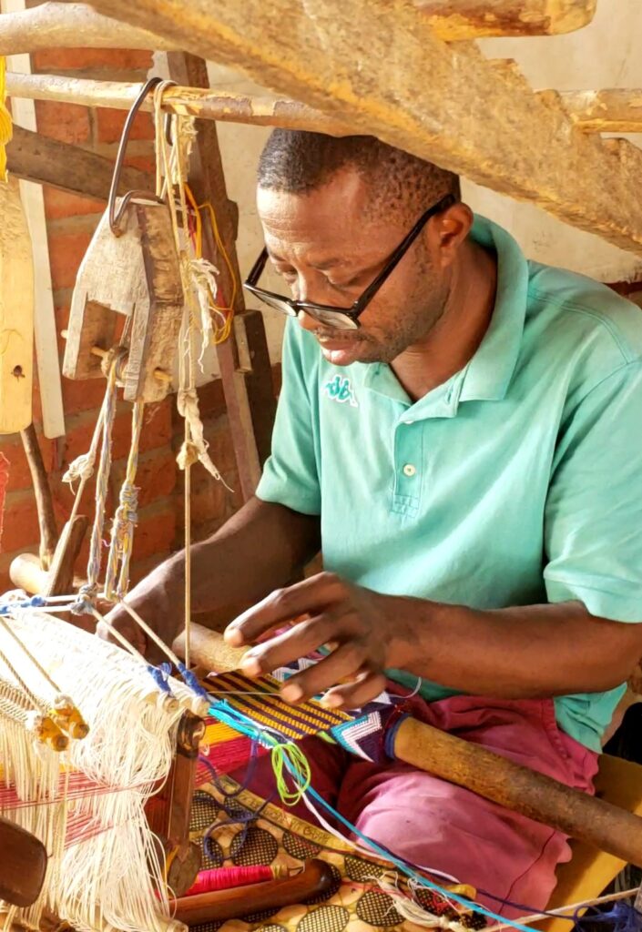 A man is working with colorful cloth.