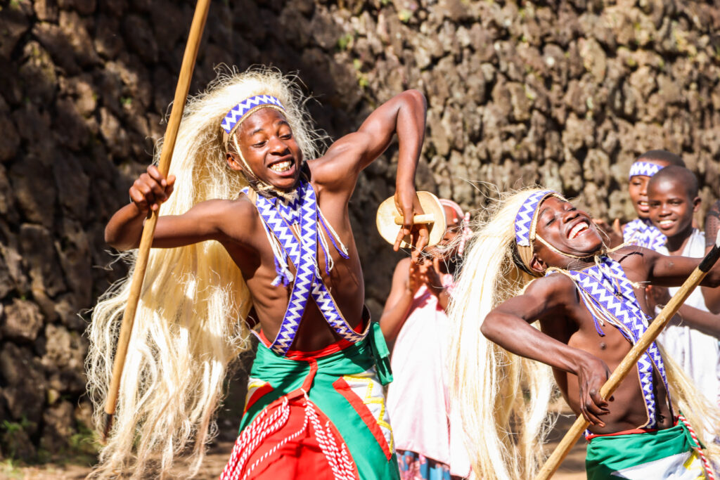 Two individuals are dancing, they are wearing bright, colorful outfits.