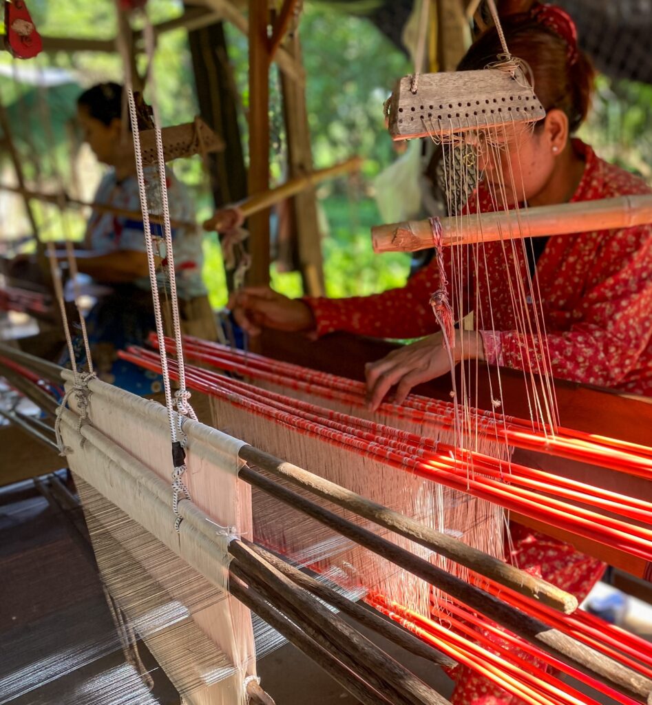 Two individuals working with fabric.