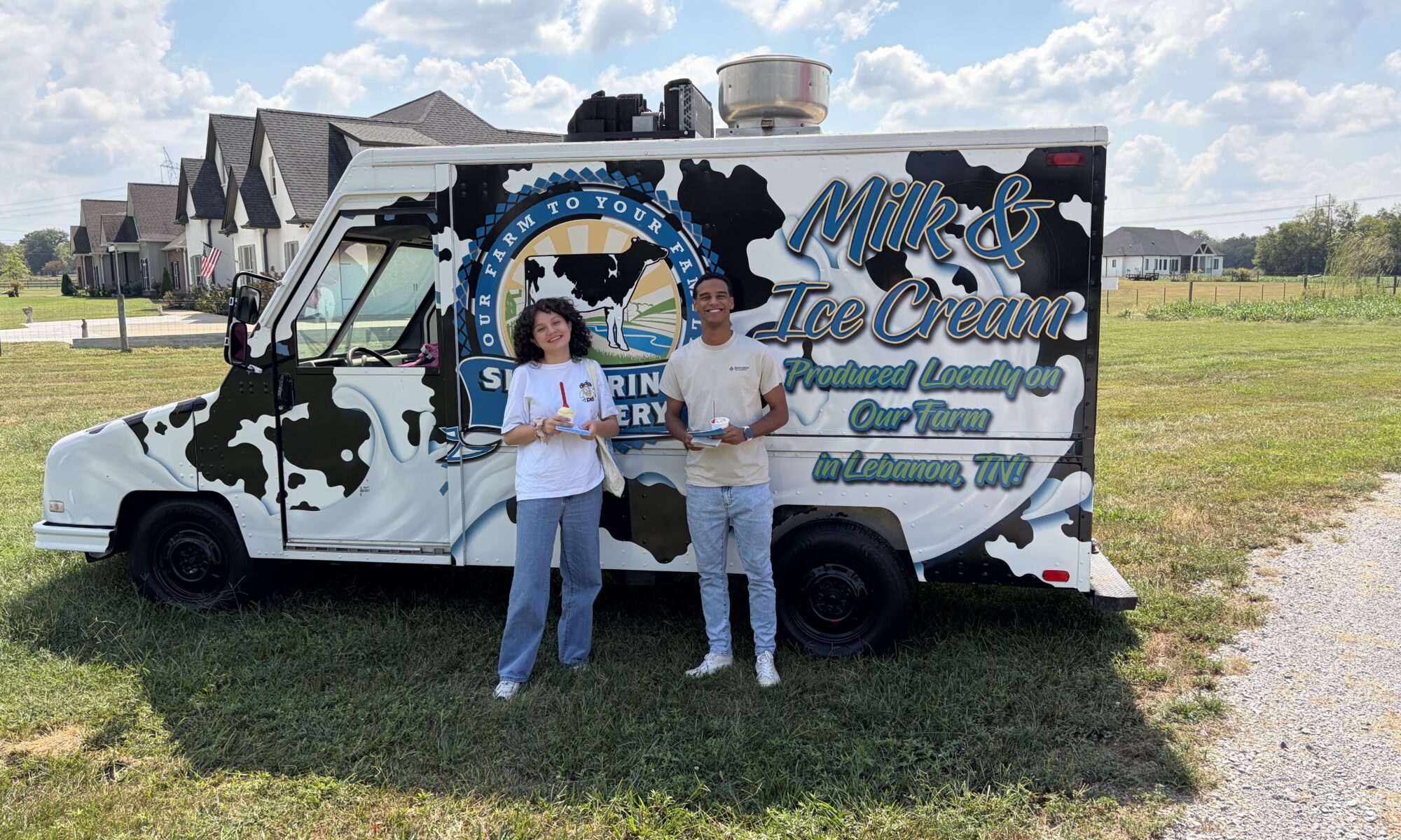 Two students standing in front of an ice cream truck.